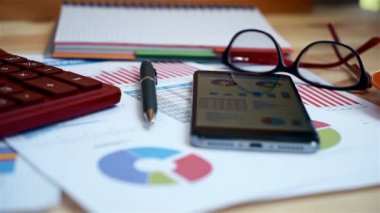 Akıllı telefon ekranında, fincan kahve, kalem, hesap makinesi tablo üzerinde hisse senedi istatistikleri