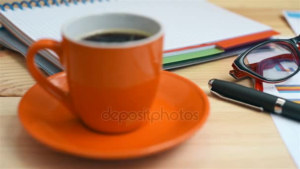 Чашка кофе, инвестиционные графики и фондовая статистика, мобильный телефон, ручка и блокнот — стоковое видео