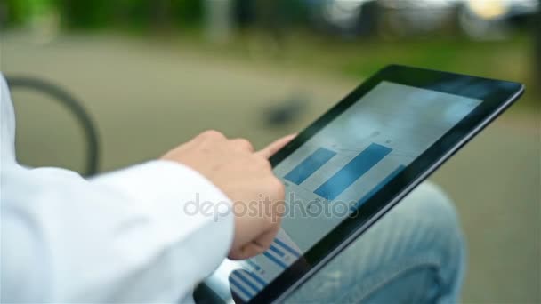 Businessman In Park Analyzing Start Up Report On Touch Pad — Stock Video