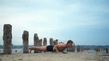 Bozulmamış sahilde poz yapan yoga erkek