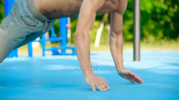 Gespierde Man uitoefening Push-ups op speeltuin buiten. Slow Motion-Effect. CrossFit Concept — Stockvideo