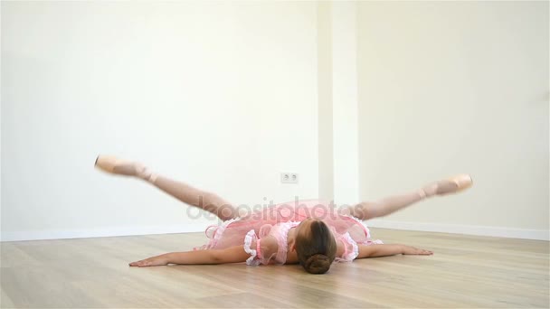 Pequeña bailarina de ballet estirando las piernas en clase — Vídeo de stock