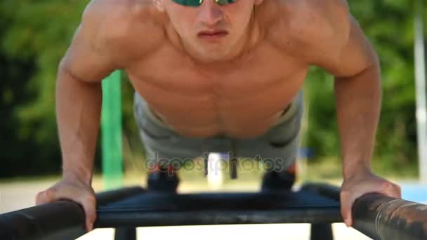 Man Shakes His Muscles On Bar In City Park. Crossfit Concept — Stock Video