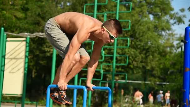 Muskularny mężczyzna wykonuje Handstand na poręczach — Wideo stockowe