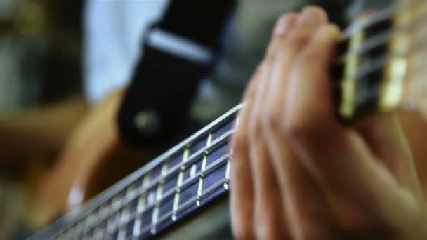 Człowiek główny gitarzysta gra na elektrycznej gitarze basowej. Z bliska — Wideo stockowe