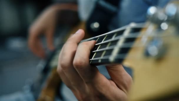 Músico de rock tocando en una guitarra baja. Efecto de cámara lenta — Vídeo de stock