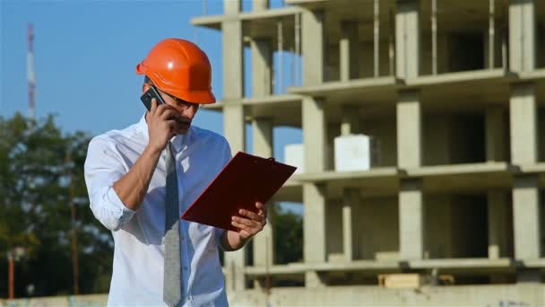 Ingeniero habla en el teléfono móvil — Vídeos de Stock