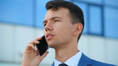 Cep telefonu üzerinde konuşurken mutlu iş adamı. Ağır çekim etkisi