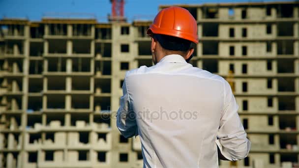 Der Ingenieur Spricht Auf Der Baustelle Ausdrucksstark Mit Dem Handy — Stockvideo