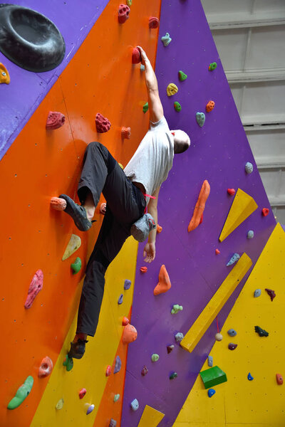 Climber On Artificial Climbing Wall In Bouldering Gym Without Insurance.