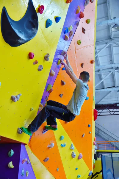 年轻人在体育馆里爬上练习墙 极端和健康的生活方式概念 — 图库照片