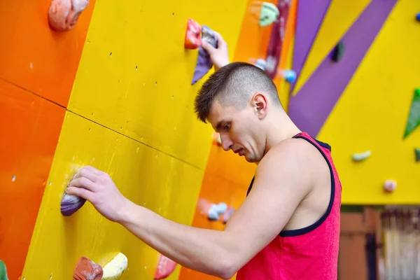 年轻人在体育馆里爬上练习墙 靠近点 — 图库照片