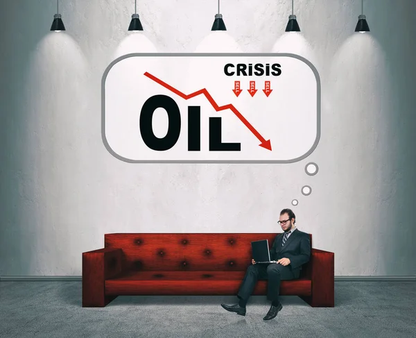 ラップトップを持つビジネスマンはソファに座って石油価格の下落を考えています ビジネスと金融危機の概念 — ストック写真