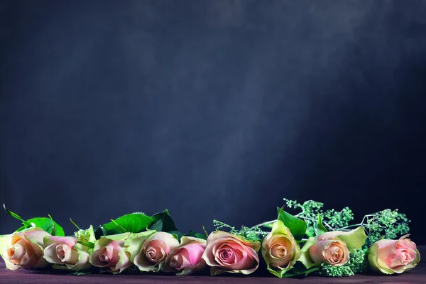 Różowe kwiaty są na stole na ciemne tło. Przestrzeń dla text lub image — Zdjęcie stockowe