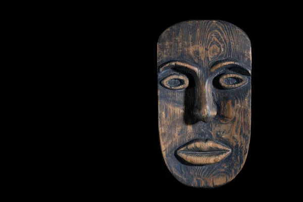 Die Maske besteht aus Holz isoliert auf schwarzem Hintergrund. Freiraum für Text — Stockfoto