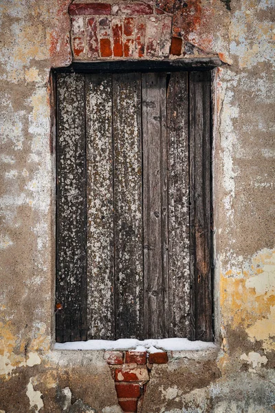 The entrance to the building boarded up in the concrete wall — Stock Photo, Image