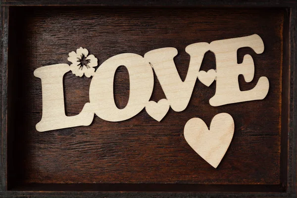 Inscription love and heart on a wooden background — Stock Photo, Image