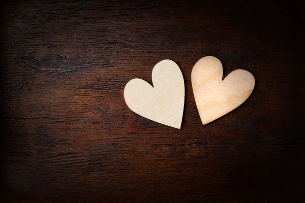 Twee harten - symbool van de liefde. Donkere houten achtergrond, ruimte voor design — Stockfoto