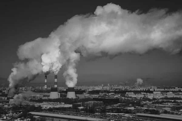 Városképet gazdagító épületnek szánták cső és a füst a szemben az ég növény. fekete-fehér fotográfia sötét stílusban — Stock Fotó