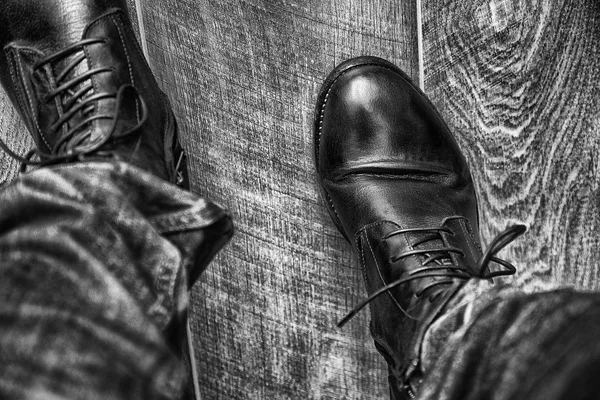 ジーンズと寄木細工の床の背景に高い革靴メンズ足 — ストック写真