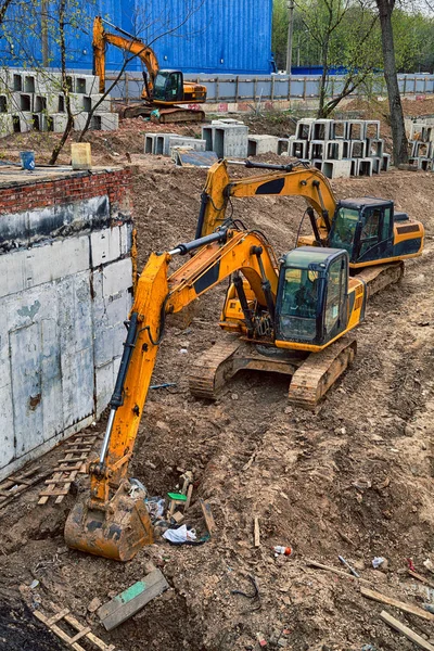 Escavadoras amarelas a cavar o chão. Local de construção — Fotografia de Stock