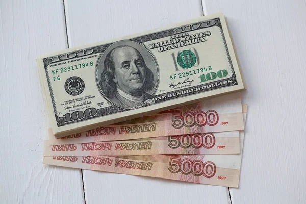 Billetes en dólares estadounidenses y rublos rusos. Un billete de cien dólares y cinco mil rublos —  Fotos de Stock