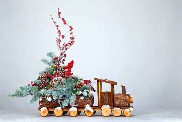 Kerstmis achtergrond. Decoratieve stoomlocomotief, versierd met kerstboom takken, speelgoed en bessen. Vrije ruimte voor uw tekst of ontwerp — Stockfoto