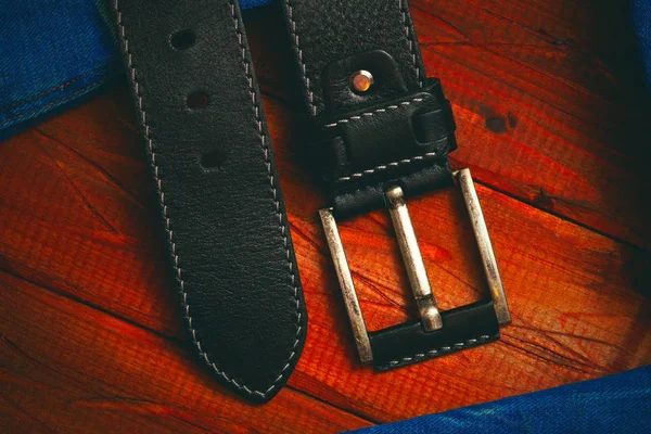 Cintura in pelle nera con fibbia cucita con filo bianco, primo piano vista dall'alto — Foto Stock