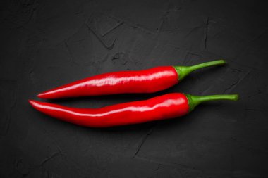 Siyah arka planda kırmızı biberler, üst manzara.