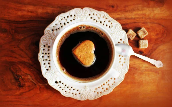 Valentine's day concept with coffee cup and heart shape over rustic background. Coffee cup with heart on a wooden table. — Stock Photo, Image