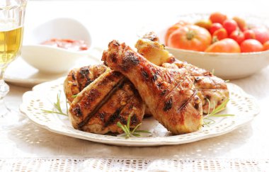 Dinner background. Grilled chicken drumsticks with rosemary. clipart