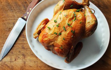 Ahşap masa üzerinde kızarmış bütün tavuk. Üstten Görünüm.