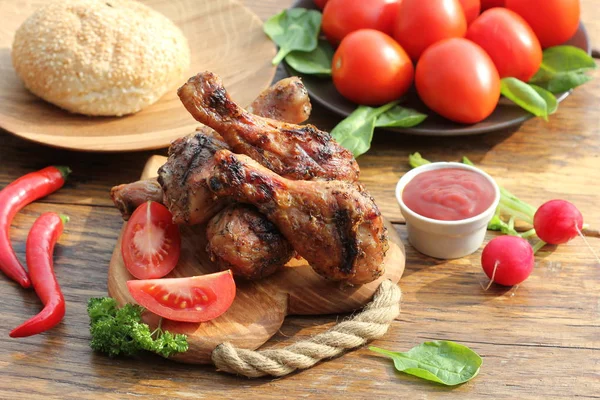 Grilled chicken legs on cutting board.Rustic dinner background. — Stock Photo, Image