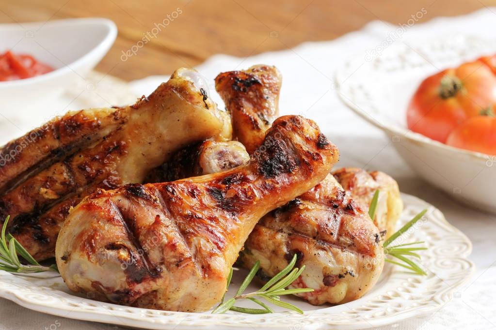 Grilled chicken legs with rosemary on table