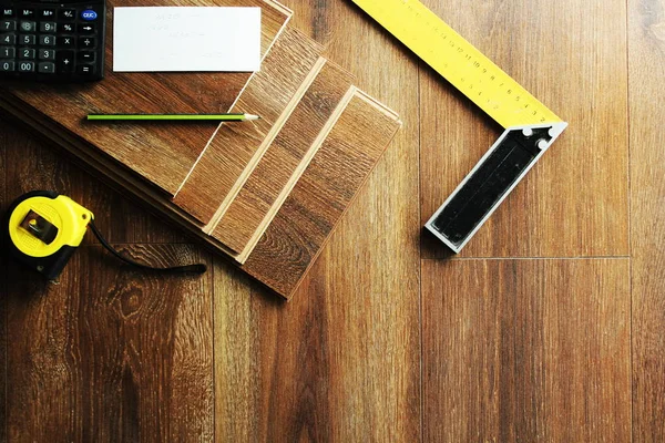 Laminato tavole da pavimento e strumenti su sfondo di legno — Foto Stock