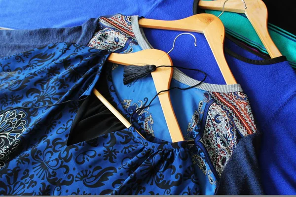 Roupas femininas de cor azul em cabides de madeira — Fotografia de Stock