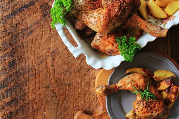 Gegrillte Hähnchenkeule mit Kartoffeln zum Garnieren. Ansicht von oben. hölzerner Hintergrund. — Stockfoto