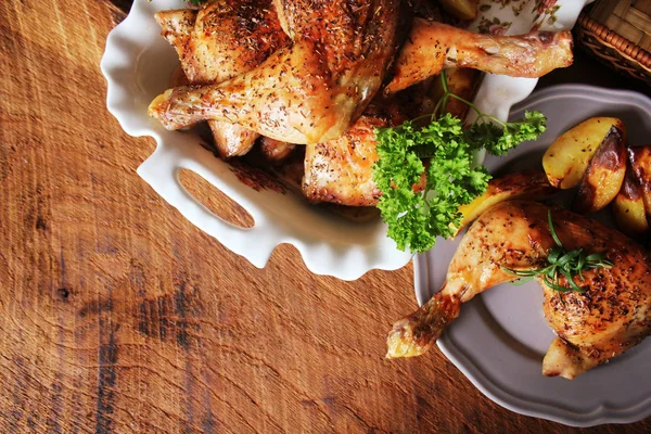 Gegrillte Hähnchenkeule mit Kartoffeln zum Garnieren. Ansicht von oben. hölzerner Hintergrund. — Stockfoto