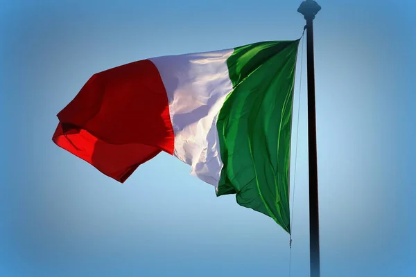 Італійський прапор розвіваються на вітрі, з синього неба — стокове фото