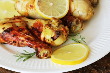 Ahşap masa rosemary ile beyaz tabakta üzerine hardallı tavuk budu ızgara. Barbekü akşam yemeği arka plan