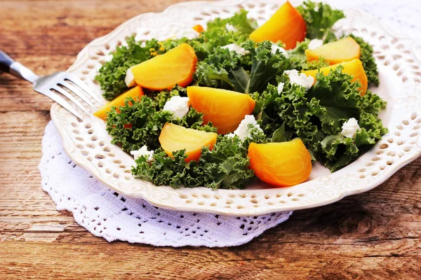 Salada de beterraba dourada saudável com alface de couve fresca, nozes, queijo feta em fundo de madeira — Fotografia de Stock