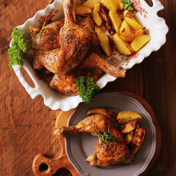 Gegrilltes Hühnerviertel mit Kartoffeln zum Garnieren. Ansicht von oben. hölzerner Hintergrund — Stockfoto