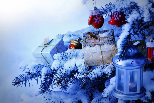 Doğal çam ağacı karla kaplı... Noel dekorasyon köknar ağacı dalı üzerinde asılı. Dalda döşeme hediye kutusu — Stok fotoğraf