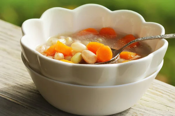 Sopa de verduras con frijoles y zanahorias sobre fondo verde —  Fotos de Stock