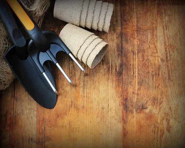 Gardening concept background with garden tools and pots on wooden background. — Stock Photo, Image