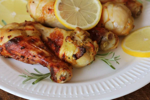 Pernas de frango grelhadas com mostarda na mesa de madeira servida em prato branco com alecrim. churrasco jantar fundo — Fotografia de Stock