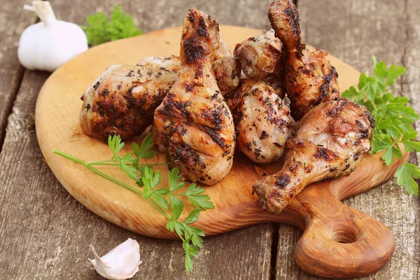 Grilled chicken legs on cutting board.Rustic dinner background — Stock Photo, Image