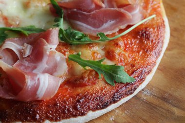 Jambon füme ve rucola ahşap arka plan üzerinde pizza