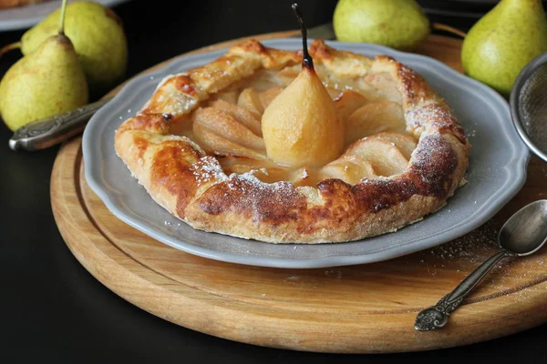 Homemade galette with pears on black background. French cuisine - Breton galette. Sweet open pie — Stock Photo, Image