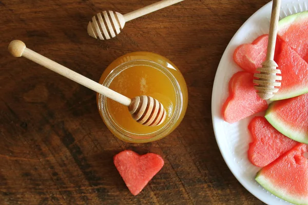 Γυαλί με μέλι και watermelion φέτες σε σκούρο φόντο. Ξύλινη κουτάλα. Επιλεκτική εστίαση — Φωτογραφία Αρχείου